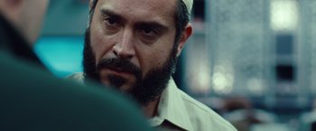 Movie still from “Non-Stop” (2014), directed by Jaume Collet-Serra – A man with a beard is looking at the camera; Close Up shot, Over the shoulder angle
