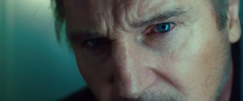 Movie still from “Non-Stop” (2014), directed by Jaume Collet-Serra – A man's face with blue eyes; Extreme Close Up shot, Over the shoulder angle