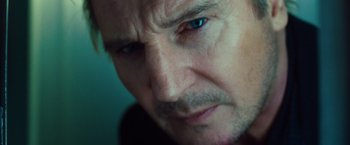 Movie still from “Non-Stop” (2014), directed by Jaume Collet-Serra – A man's face with blue eyes; Close Up shot, Over the shoulder angle