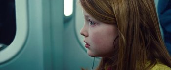 Movie still from “Non-Stop” (2014), directed by Jaume Collet-Serra – A young girl is listening to music on a train; Close Up shot, Over the shoulder angle