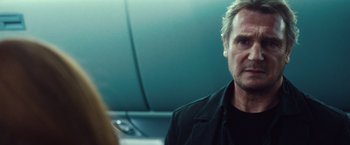 Movie still from “Non-Stop” (2014), directed by Jaume Collet-Serra – A man in a black jacket is looking at a woman; Close Up shot, Over the shoulder angle