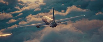 Movie still from “Non-Stop” (2014), directed by Jaume Collet-Serra – An airplane flying through a cloudy sky on a sunny day; Extreme Wide shot, Overhead angle