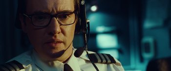 Movie still from “Non-Stop” (2014), directed by Jaume Collet-Serra – A person wearing headphones and glasses; Close Up shot, Low angle