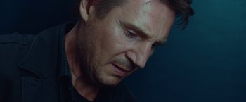Movie still from “Non-Stop” (2014), directed by Jaume Collet-Serra – A man's face in a dark room; Close Up shot, Low angle