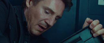 Movie still from “Non-Stop” (2014), directed by Jaume Collet-Serra – A man's face as he stares off into the distance; Close Up shot, Low angle