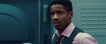 Movie still from “Non-Stop” (2014), directed by Jaume Collet-Serra – A man in a pink shirt and a blue vest; Close Up shot, Over the shoulder angle
