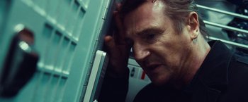 Movie still from “Non-Stop” (2014), directed by Jaume Collet-Serra – A person leaning against a wall; Close Up shot, Low angle