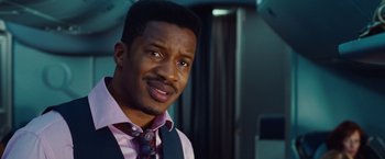 Movie still from “Non-Stop” (2014), directed by Jaume Collet-Serra – A person wearing a suit and a tie; Close Up shot, Over the shoulder angle