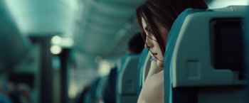 Movie still from “Non-Stop” (2014), directed by Jaume Collet-Serra – A woman sitting on a train looking out the window; Close Up shot, Over the shoulder angle