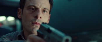 Movie still from “Non-Stop” (2014), directed by Jaume Collet-Serra – A person holding a gun; Close Up shot, Low angle