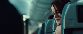 Movie still from “Non-Stop” (2014), directed by Jaume Collet-Serra – A woman sitting on a train with her eyes closed; Close Up shot, Over the shoulder angle
