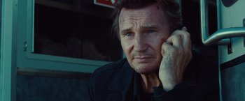 Movie still from “Non-Stop” (2014), directed by Jaume Collet-Serra – A person holding a cell phone to his ear; Close Up shot, Low angle