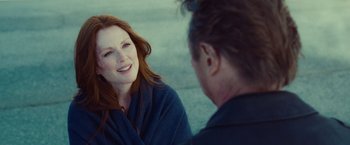 Movie still from “Non-Stop” (2014), directed by Jaume Collet-Serra – A woman sitting next to a man on the ground; Close Up shot, Over the shoulder angle