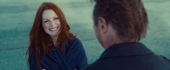 Movie still from “Non-Stop” (2014), directed by Jaume Collet-Serra – A woman smiles at a man in a blue shirt; Close Up shot, Over the shoulder angle