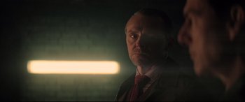 Movie still from “Mission: Impossible - Fallout” (2018), directed by Christopher McQuarrie – A man in a suit and tie in a dark room; Close Up shot, Low angle
