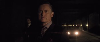 Movie still from “Mission: Impossible - Fallout” (2018), directed by Christopher McQuarrie – A man wearing a suit and tie in the dark; Close Up shot, Over the shoulder angle