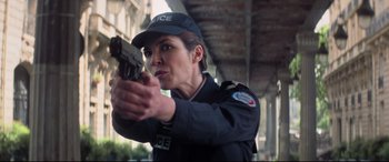Movie still from “Mission: Impossible - Fallout” (2018), directed by Christopher McQuarrie – A police officer holding a gun in her hand; Close Up shot, Low angle