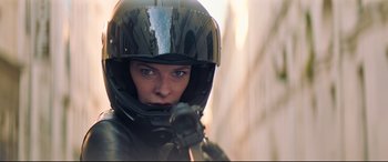 Movie still from “Mission: Impossible - Fallout” (2018), directed by Christopher McQuarrie – A woman wearing a motorcycle helmet while holding a gun; Close Up shot, Low angle