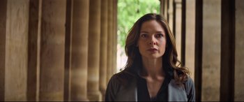 Movie still from “Mission: Impossible - Fallout” (2018), directed by Christopher McQuarrie – A woman standing in front of a pillar and trees; Close Up shot, Low angle