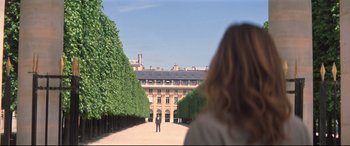 Movie still from “Mission: Impossible - Fallout” (2018), directed by Christopher McQuarrie – A person standing on a path in front of a building; Extreme Wide shot, Over the shoulder angle