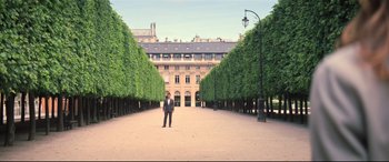Movie still from “Mission: Impossible - Fallout” (2018), directed by Christopher McQuarrie – A man in a suit standing in front of a row of trees; Extreme Wide shot, High angle