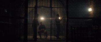 Movie still from “Mission: Impossible - Fallout” (2018), directed by Christopher McQuarrie – A group of people standing in a jail cell; Wide shot, High angle