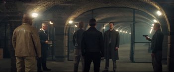 Movie still from “Mission: Impossible - Fallout” (2018), directed by Christopher McQuarrie – A group of people standing in a tunnel; Wide shot, Over the shoulder angle