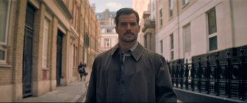Movie still from “Mission: Impossible - Fallout” (2018), directed by Christopher McQuarrie – A man with a beard is standing on the sidewalk; Medium shot, Over the shoulder angle