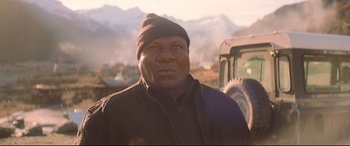 Movie still from “Mission: Impossible - Fallout” (2018), directed by Christopher McQuarrie – A man wearing a hat standing in front of a tractor; Close Up shot, Low angle