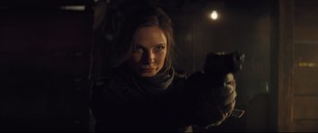 Movie still from “Mission: Impossible - Fallout” (2018), directed by Christopher McQuarrie – A woman is holding a gun in a dark room; Close Up shot, Over the shoulder angle