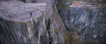 Movie still from “Mission: Impossible - Fallout” (2018), directed by Christopher McQuarrie – A man standing on a rock ledge on top of a cliff; Extreme Wide shot, High angle