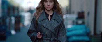 Movie still from “Mission: Impossible - Ghost Protocol” (2011), directed by Brad Bird – A woman in a gray coat is walking down the street; Medium shot, Low angle