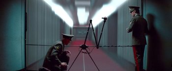 Movie still from “Mission: Impossible - Ghost Protocol” (2011), directed by Brad Bird – A man in a military uniform standing next to an antenna; Wide shot, Low angle