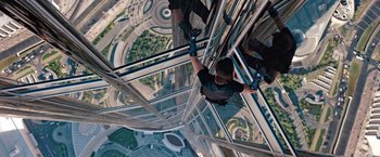 Movie still from “Mission: Impossible - Ghost Protocol” (2011), directed by Brad Bird – A man hanging from the side of a skyscraper; Wide shot, Overhead angle