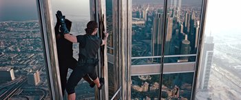 Movie still from “Mission: Impossible - Ghost Protocol” (2011), directed by Brad Bird – A man standing next to a window on a skyscraper; Wide shot, Overhead angle