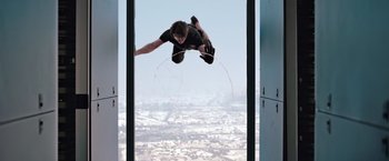 Movie still from “Mission: Impossible - Ghost Protocol” (2011), directed by Brad Bird – A man flying through the air while riding a skateboard; Wide shot, Overhead angle