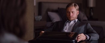 Movie still from “Mission: Impossible - Ghost Protocol” (2011), directed by Brad Bird – A man in a suit sitting in front of a table; Medium shot, Over the shoulder angle
