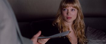 Movie still from “Mission: Impossible - Ghost Protocol” (2011), directed by Brad Bird – A young woman holding a piece of paper in front of her face; Close Up shot, Over the shoulder angle