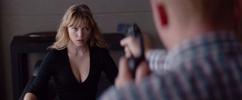 Movie still from “Mission: Impossible - Ghost Protocol” (2011), directed by Brad Bird – A woman in a black shirt is holding a gun; Close Up shot, Over the shoulder angle