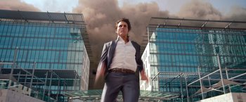 Movie still from “Mission: Impossible - Ghost Protocol” (2011), directed by Brad Bird – A man in a business suit standing in front of a building; Medium shot, Low angle