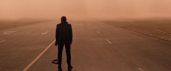 Movie still from “Mission: Impossible - Ghost Protocol” (2011), directed by Brad Bird – A man standing on the side of a road in the middle of the day; Wide shot, Low angle