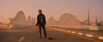 Movie still from “Mission: Impossible - Ghost Protocol” (2011), directed by Brad Bird – A man standing on the side of a road next to a dog; Wide shot, Low angle