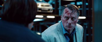 Movie still from “Mission: Impossible - Ghost Protocol” (2011), directed by Brad Bird – A man in a white jacket with a red spot on his face; Close Up shot, Over the shoulder angle