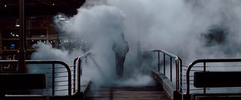 Movie still from “Mission: Impossible - Ghost Protocol” (2011), directed by Brad Bird – A person walking on a bridge with smoke coming from it; Wide shot, High angle