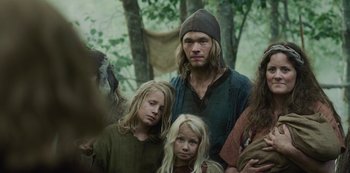 A group of people standing next to each other in a forest