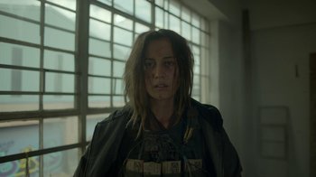 Movie still from “Oats Studios” (2017), directed by Neill Blomkamp – A person with long hair and a jacket; Close Up shot, Over the shoulder angle