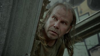 Movie still from “Oats Studios” (2017), directed by Neill Blomkamp – A man with long hair is looking at the camera; Close Up shot, Low angle