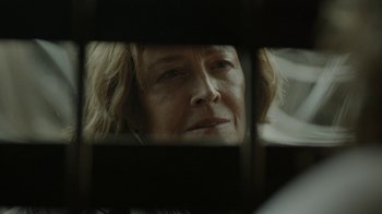 Movie still from “Oats Studios” (2017), directed by Neill Blomkamp – An older woman looking at her reflection in a mirror; Close Up shot, Over the shoulder angle