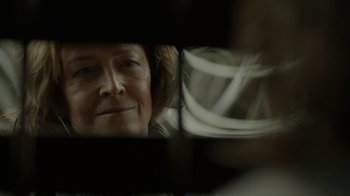 Movie still from “Oats Studios” (2017), directed by Neill Blomkamp – An older woman looking at her reflection in a mirror; Close Up shot, Over the shoulder angle