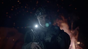 Movie still from “Oats Studios” (2017), directed by Neill Blomkamp – A man with a flashlight is holding a gun; Close Up shot, Over the shoulder angle